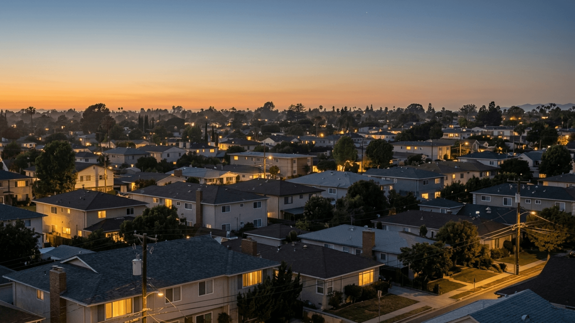 Suburban neighborhood at dusk with homes lit up during evening off-peak electricity hours